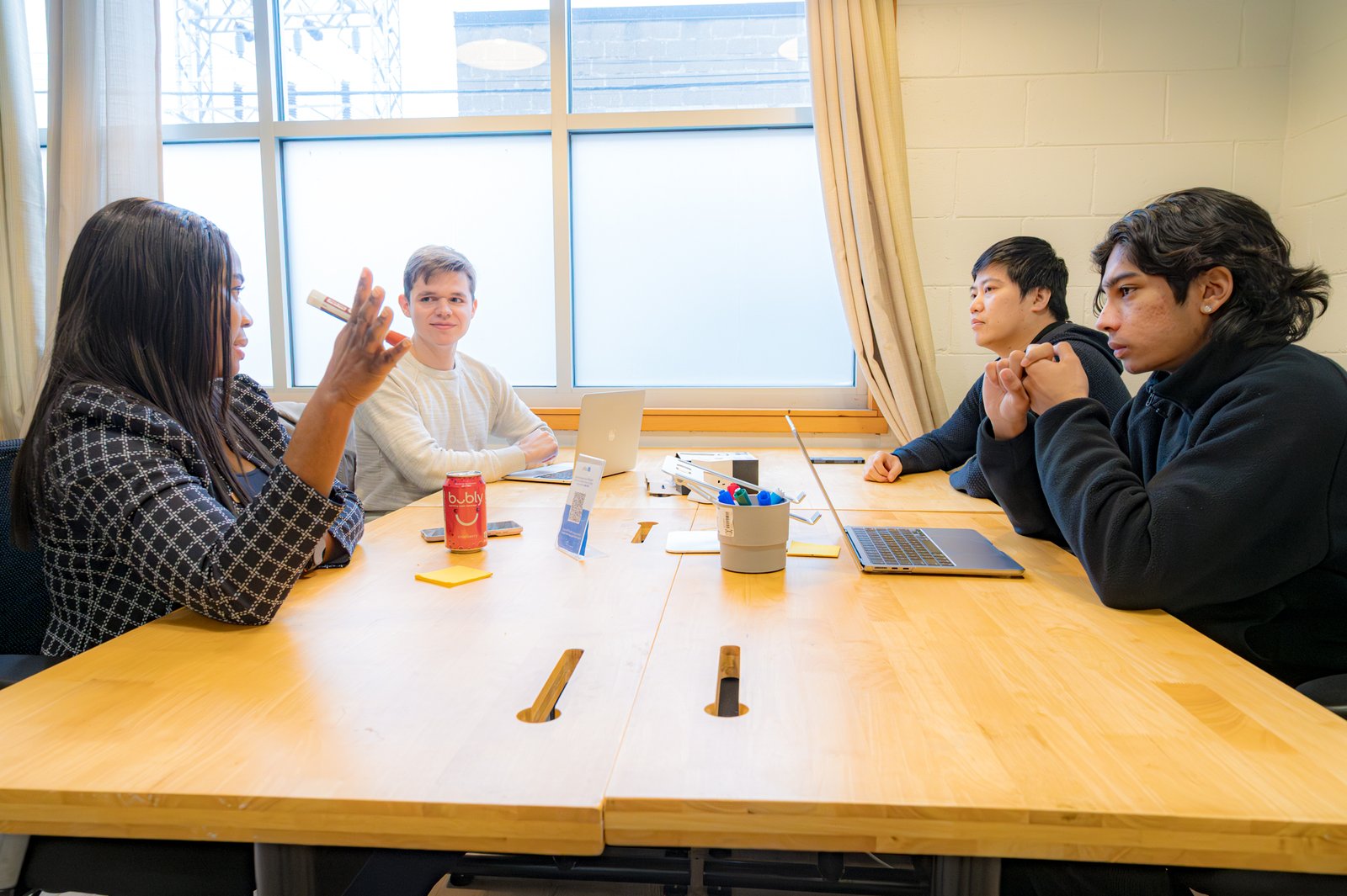 Four people in a meeting room having a disscussion.
