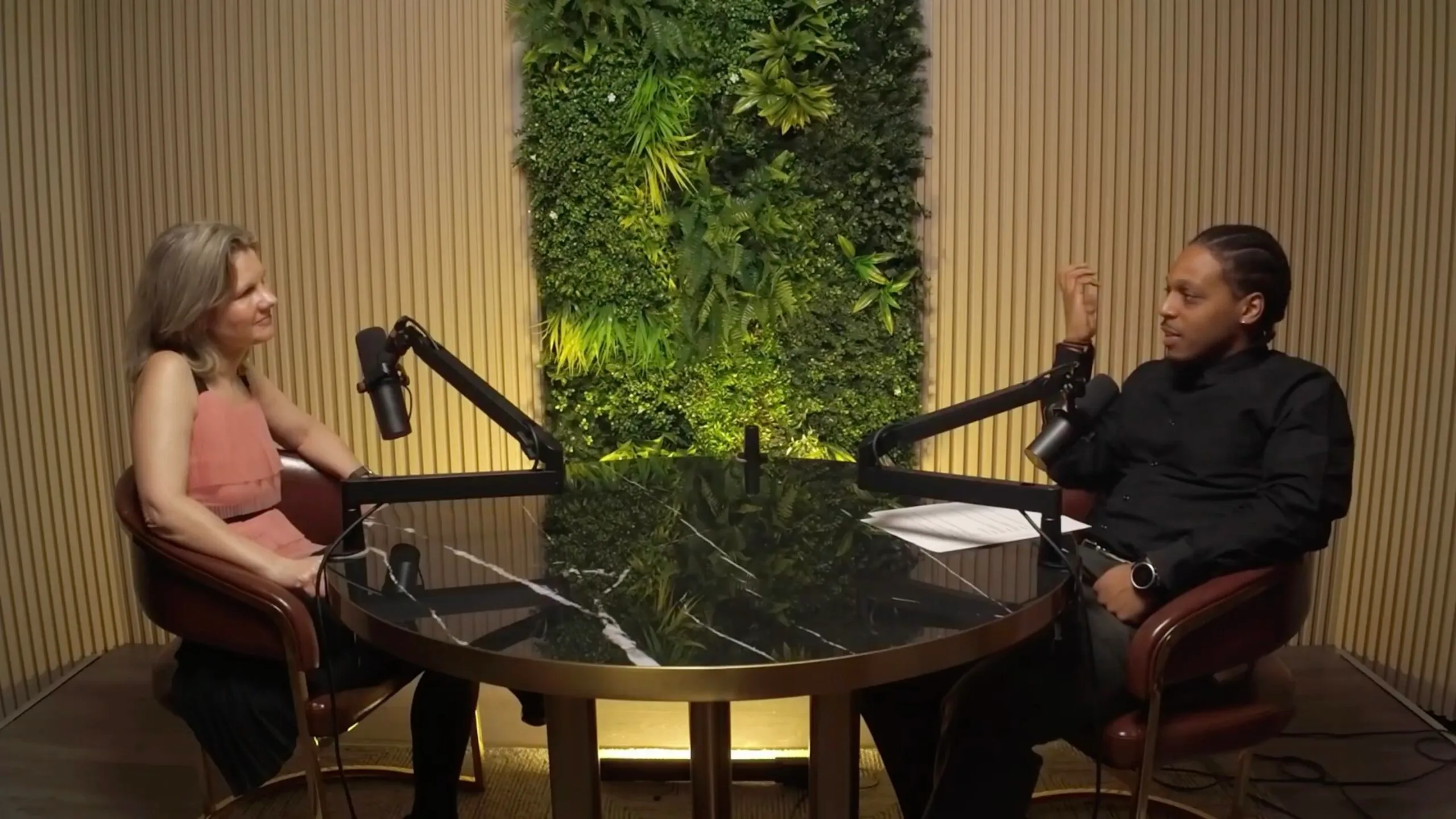 Screenshot Two people speaking together in a podcast environment.