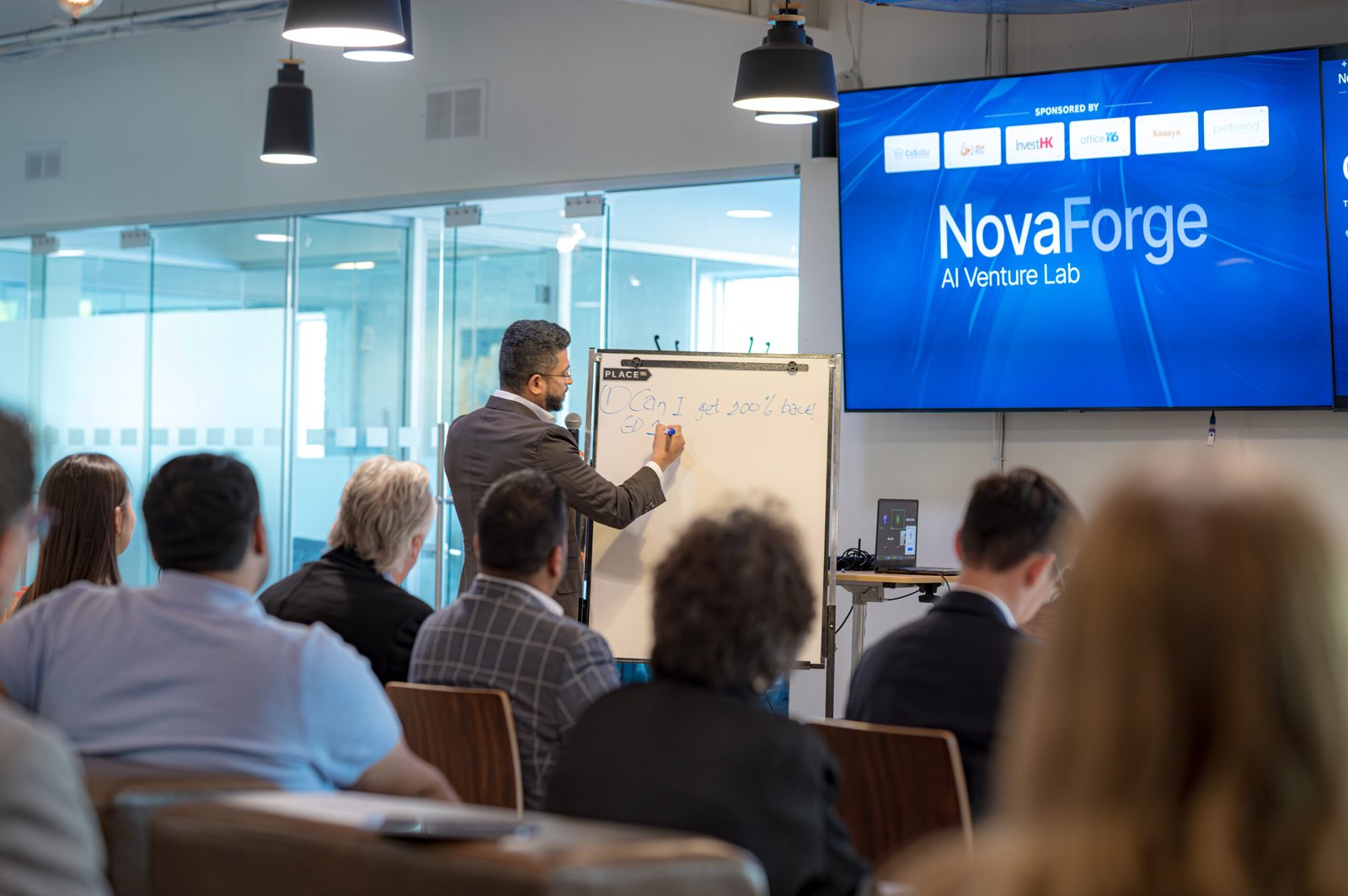 Man writing on an easel at a NovaForge event.