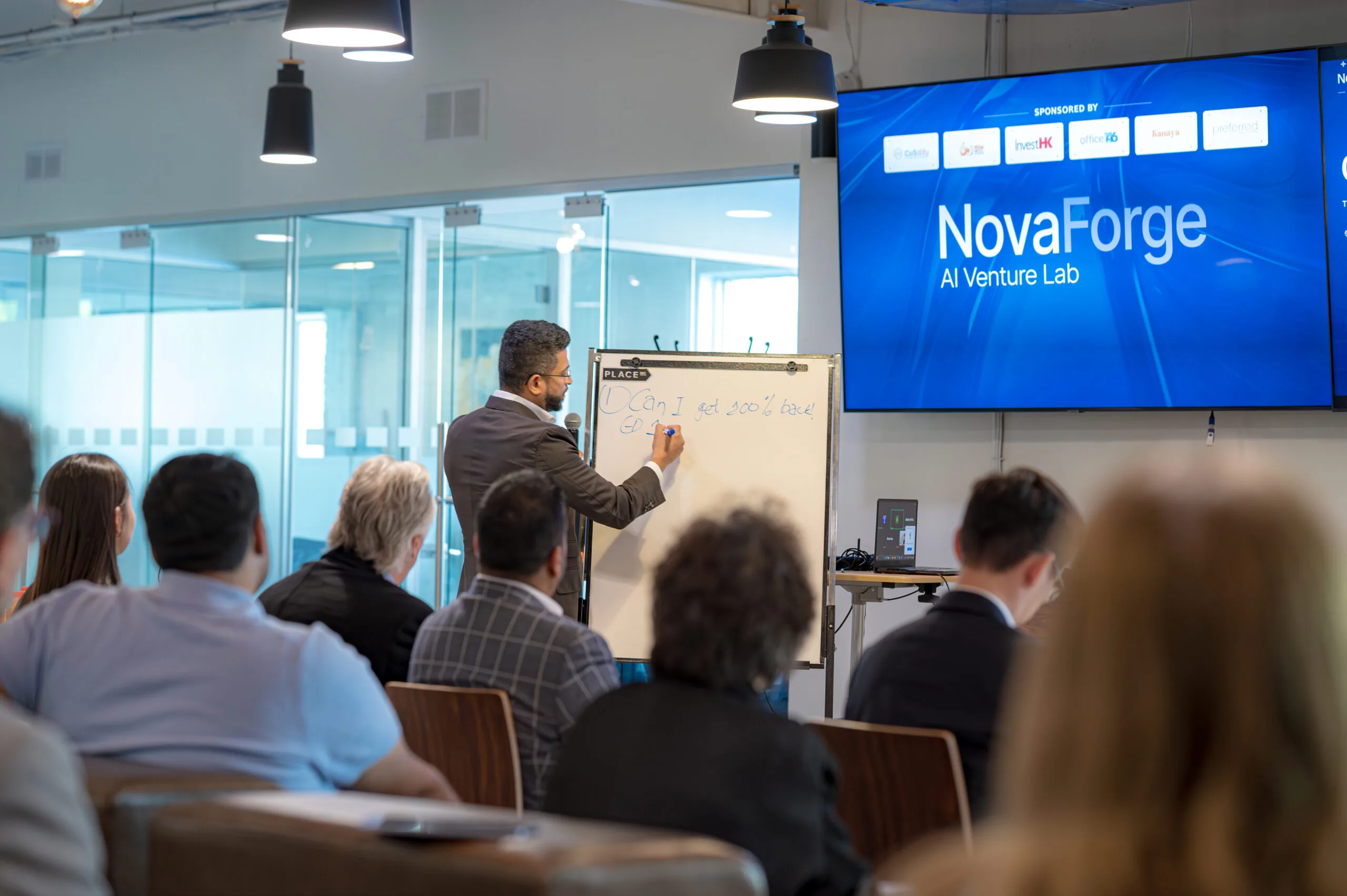 Man writing on an easel at a NovaForge event.